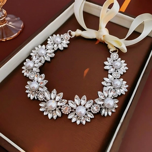 Detail of floral necklace with pearls and crystals in a luxury brown gift box