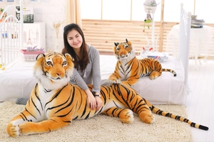 Detail view of large and small stuffed tiger plushies showing realistic fur texture