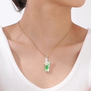 Detailed close-up of Saint Jude pendant with gold chain and green enamel on a model