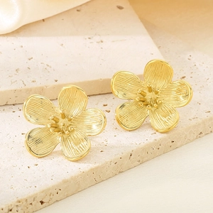 Macro shot of 18K gold plated flower earrings with brushed texture and petal detail