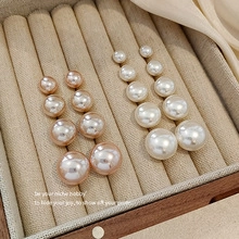 Macro shot of assorted white and champagne pearl earrings in a beige velvet jewelry box