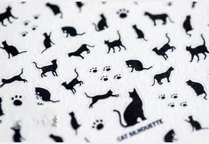 Macro detail of black cat silhouette nail stickers and paw prints with matte finish