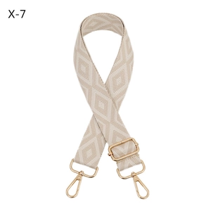 Close-up of adjustable woven shoulder strap with geometric jacquard pattern and gold hooks