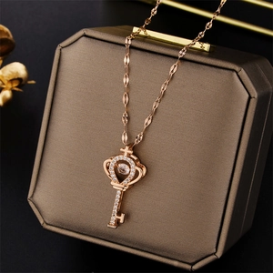 Rose gold key pendant necklace with dancing stone on a premium jewelry gift box