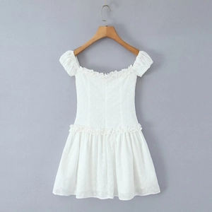 Close-up of white off-shoulder mini dress with puff sleeves and hollow embroidery detail