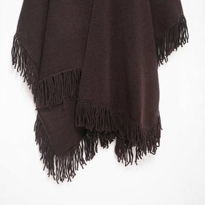 Dark brown knit poncho featuring heavy fabric texture and thick fringe tassels hem detail