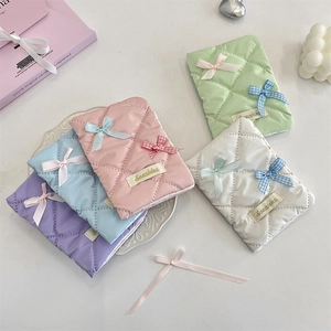 Detailed view of quilted bow passport covers in five pastel colors with soft nylon texture