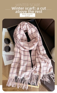 Detailed view of pink plaid cashmere-like winter scarf with fringe in a lifestyle setting