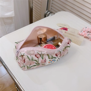 Close-up of pink tulip floral pattern and secure zipper detail on the cotton makeup bag