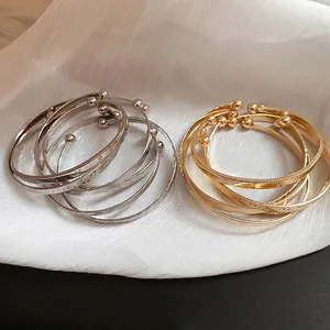 Polished metal open bracelet set with LOVE engraving and star pattern in gold and silver