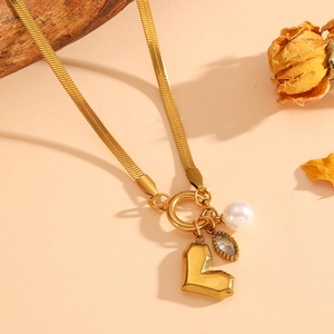 Gold snake chain necklace with heart pendant, pearl, and droplet gemstone charms