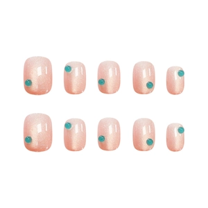 Pink cat eye press-on nails with blue bead accents for professional manicures