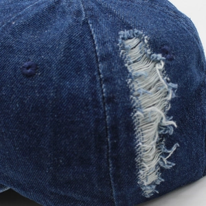 Dettaglio in denim lavato vintage con fori consumati e consistenza in stile rétro