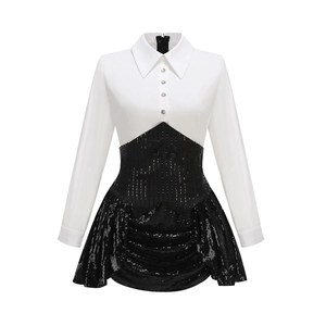 Détail de la robe à paillettes noires cousue avec une chemise blanche à manches longues