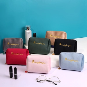 Variety of colorful velvet cosmetic bags with gold embroidery and interior organizers