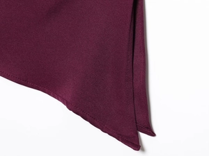 Macro detail of wine red fabric showing fine twill texture and precision edge stitching