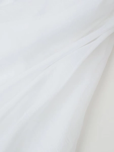 Close-up of white textured fabric with soft pleats and elegant folds on the mini dress