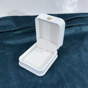 Close-up of a white PU leather jewelry box with beige lining and a gold crown detail