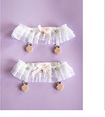 Detailed view of white lace leg rings with pink bows and heart-shaped clips for women