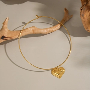 Chic 18K gold plated heart sun necklace with a rigid collar band on a soft background