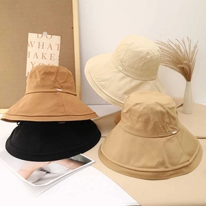 Detail view of wide brim sun hats in beige, khaki, brown and black with metal accents