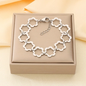 Detailed macro view of minimalist hollow flower bracelet charm in cold silver finish