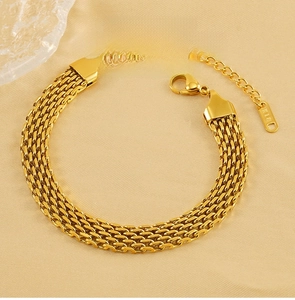 Close-up of golden stainless steel braided bracelet with K18 tag and lobster clasp