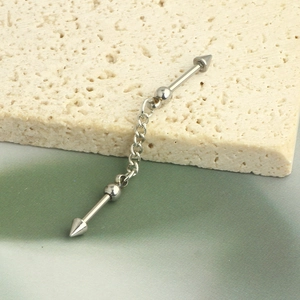 Close-up of silver industrial barbell with chain and pointed cones on stone background