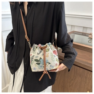 Detailed view of the ethnic jacquard floral bucket bag with brown faux leather strap