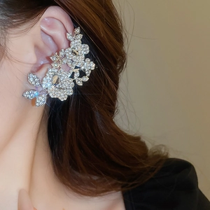 Close-up of sparkling silver floral ear cuff with rhinestones on a female ear