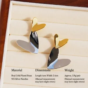 Elegant gold and silver contrast layered heart earrings in a luxury jewelry box