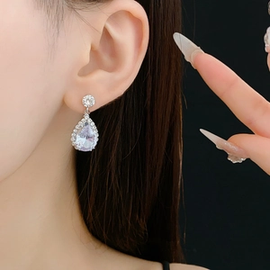 Détail de boucles d'oreilles en argent avec zircons en forme de poire et petits diamants
