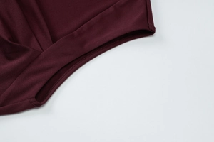 Vue macro de la texture tricotée bordeaux et détails de l'ourlet sur une robe élastique