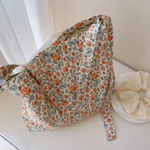Detailed close-up of small floral patterns on cream cotton canvas tote bag with side strap