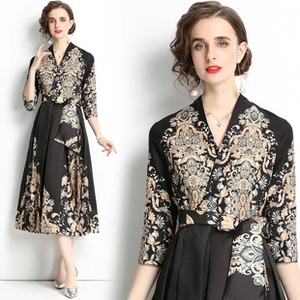 Detalle de vestido negro vintage francés con estampados dorados y cinturón fino