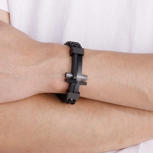 Detail shot of a black braided leather bracelet with a matte black cross metal clasp