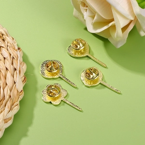 Golden heart and clover metal brooch pin backs displayed on a green background