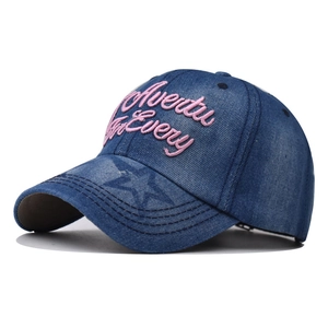 Détail de la casquette en jean bleu avec broderie rose et motif étoile sur la visière