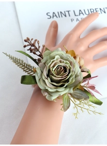 Detailed wrist corsage with dusty green rose and delicate berries for wedding ceremonies