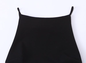 Detail des schwarzen Camisole-Ausschnitts und der dünnen Träger mit feiner Textur
