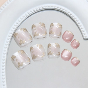 Cat-eye gold leaf press-on toenails set with French style tips on a pearl tray