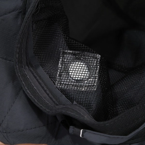 Detail of inner black quilted lining with small mesh pocket and hidden battery pack