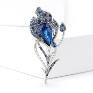 Elegant silver flower brooch with large deep blue teardrop crystal and blue rhinestones