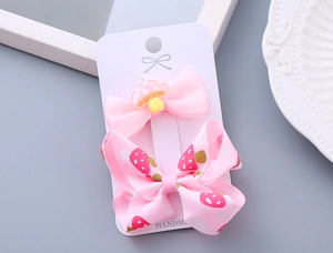 Detail of handmade pink bow hair clips with cute mushroom patterns for girls