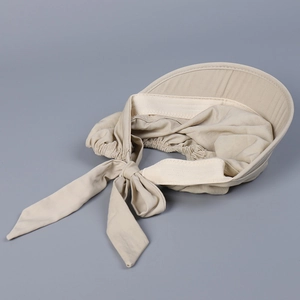 Detail showing the large back bow tie and fabric texture of the beige sun visor cap