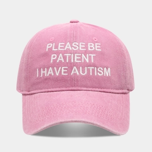 Close-up of pink washed cotton baseball cap featuring white embroidered slogan text