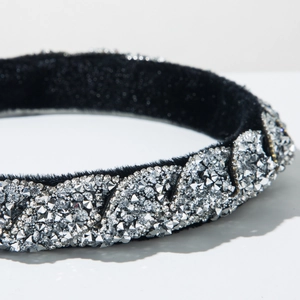 Dettaglio macro del cerchietto in velluto di lusso con strass argento e trama intrecciata