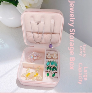 Pink portable jewelry box detail showing interior necklace hooks and ring storage slots