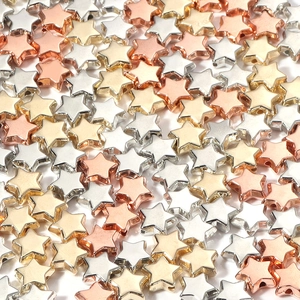 Close-up of star-shaped metallic beads in gold silver and rose gold for DIY jewelry
