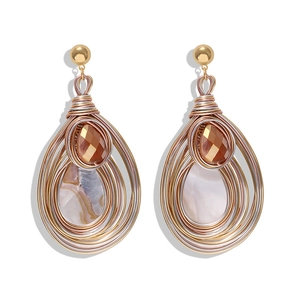 Macro detail of handmade bohemian wire-wrapped teardrop earrings with amber gemstones
